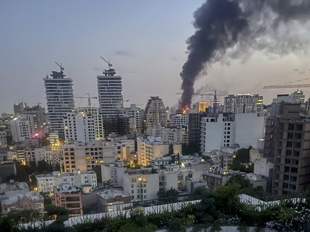 Smoke rises from the rubble of an Iranian state media building in Tehran after an Israeli airstrike on June 16, 2025. (Image: MINA/Middle East Images/AFP via Getty Images)