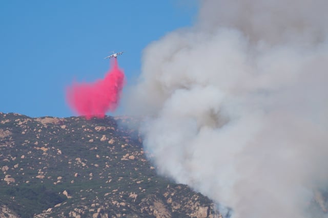 An air tanker working the Monte fire in Lakeside drops fire retardant on a hot spot north of the El Monte County Park on Tuesday.  (Nelvin C. Cepeda / The San Diego Union-Tribune)