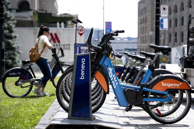 A woman returns a Bixi bike to a station in Montreal on Wednesday, June 11, 2025.