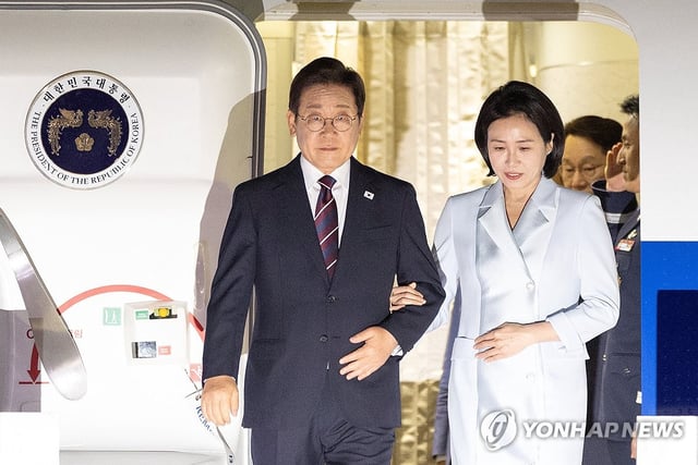 President Lee Jae Myung (L) and first lady Kim Hea kyung arrive at Seoul Air Base in Seongnam, south of Seoul, on June 19, 2025, after attending the Group of Seven summit in Canada. (Yonhap)