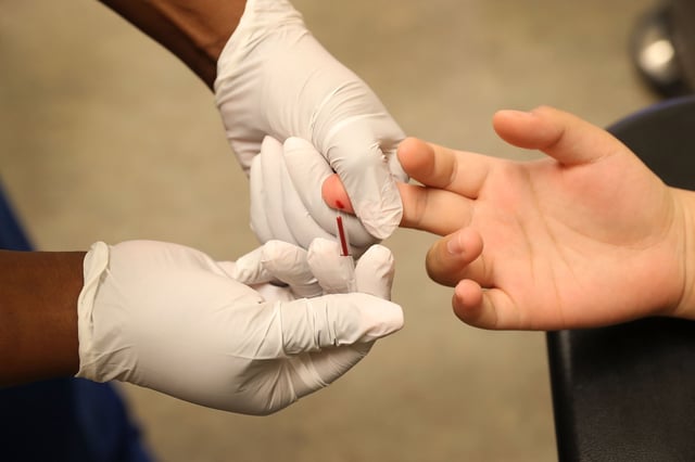 A medical assistant draws blood from a patient on National HIV Testing Day in Miami, Fla., in 2017.