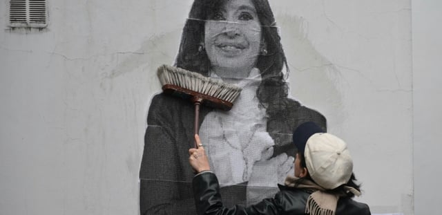 Une partisane de Cristina Kirchner colle un portrait de l'ex-présidente argentine sur un mur de la résidence de celle-ci, le 17 juin 2025 à Buenos Aires