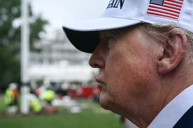 US President Donald Trump speaks to the press as workers install a large flag pole on the South Lawn of the White House in Washington, DC on June 18, 2025.