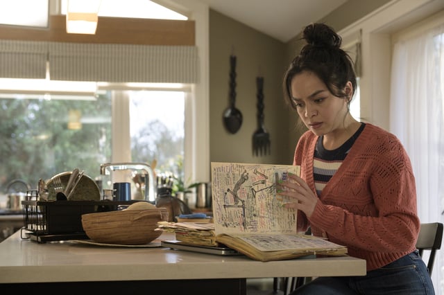 Stefani Reyes (Kaitlyn Santa Juana) looks through her grandmother's guide to surviving death in "Final Destination Bloodlines."