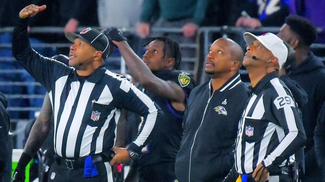 Referees and Baltimore Ravens players look into the sky to a plane or drone flying over the stadium, prompting officials to clear the field during the fourth quarter of an AFC North division rivalry in Baltimore Thursday Nov. 16, 2023.