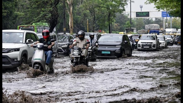 Commuters wade through a severely waterlogged road after rainfall near Vikas Marg, at ITO in New Delhi last month.