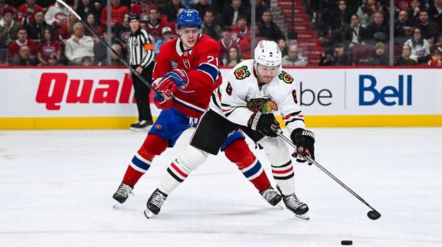 Apr 14, 2025; Montreal, Quebec, CAN; Chicago Blackhawks center Ryan Donato (8) plays the puck against Montreal Canadiens defenseman Kaiden Guhle (21) in the third period at Bell Centre. Mandatory Credit: David Kirouac-Imagn Images