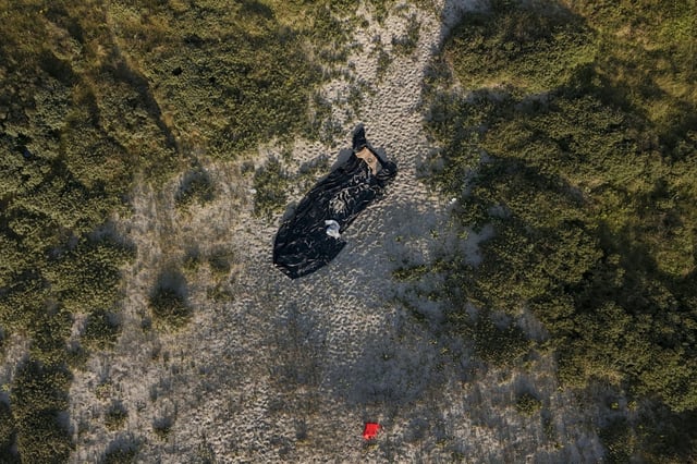 A deflated dinghy on a French beach