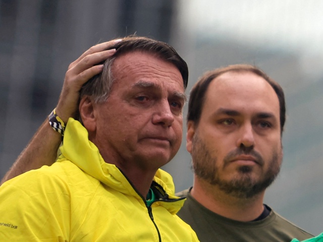 Michelle Bolsonaro (R) speaks next to her husband Brazil's former President Jair Bolsonaro (L) and their sons Carlos (2-L), Flavio (C) and Renan during a rally at Paulista Avenue in Sao Paulo, Brazil, on April 6, 2025. Brazil's former President Jair Bolsonaro led a demonstration in Sao Paulo on Sunday, the first since the supreme court decided to try him on charges of leading a coup plot. (Miguel SCHINCARIOL / AFP via Getty)