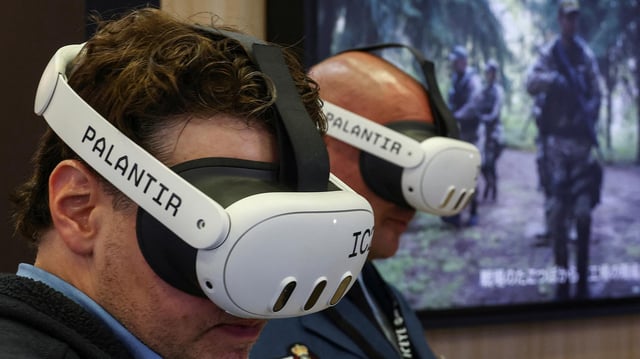 Besucher einer Messe probieren das Palantir Maven Smart System.