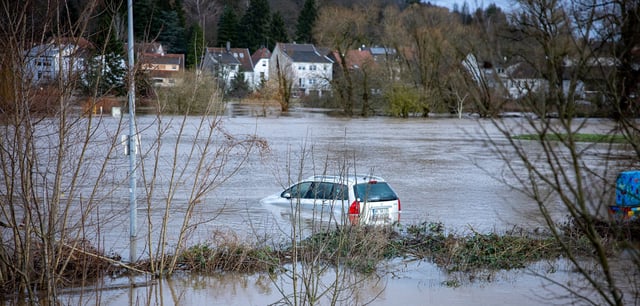Ein Auto steht wegen Hochwasser im Wasser