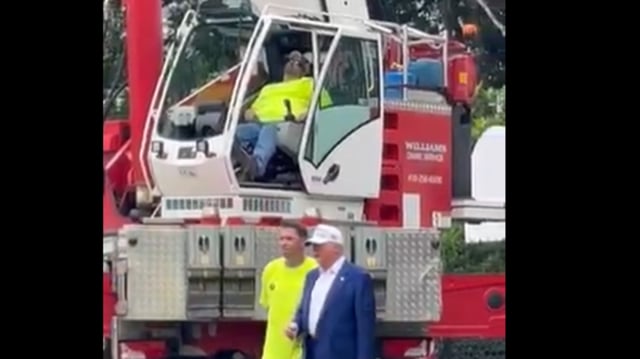 Unaware of the situation behind him, Donald Trump continued chatting with workers and admiring the structures. 