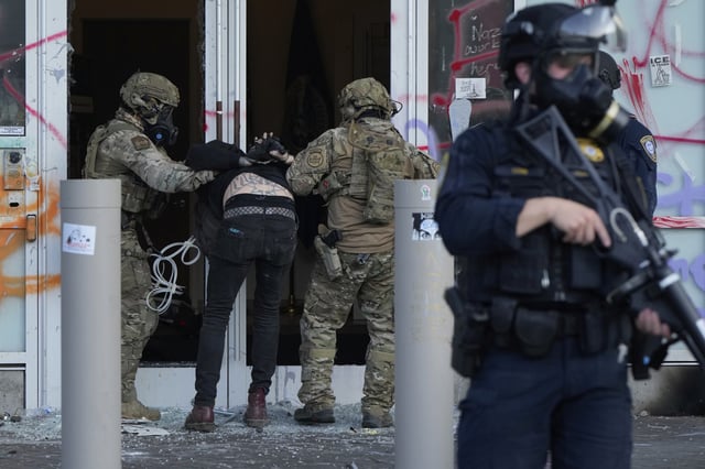 Federal agents detain a man outside the U.S. Immigration and Customs building during a protest Saturday, June 14, 2025, in Portland, Oregan