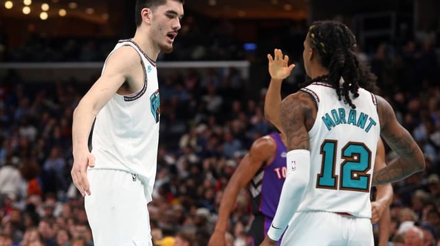 Memphis Grizzlies center Zach Edey (14) reacts with guard Ja Morant (12) during a game.