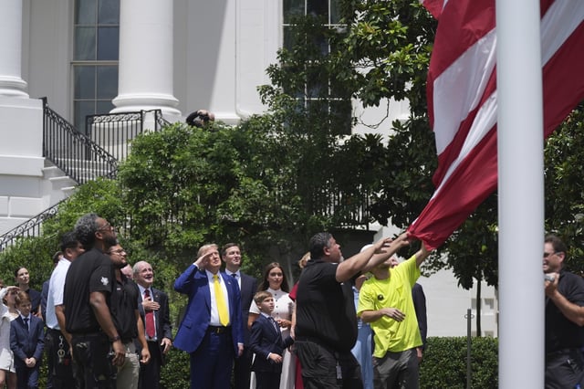 President Donald Trump salutes as a flag is raised on a newly installed flag pole on the South Lawn of the White House, Wednesday, June 18, 2025, in Washington.