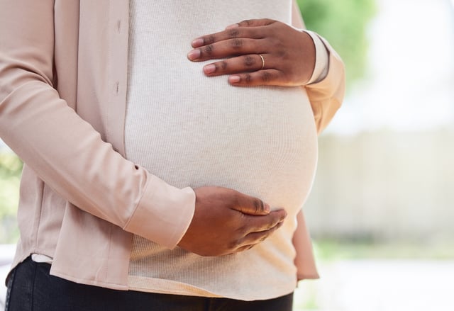 Cropped shot of an unrecognizable mother to be standing in her living room at home.