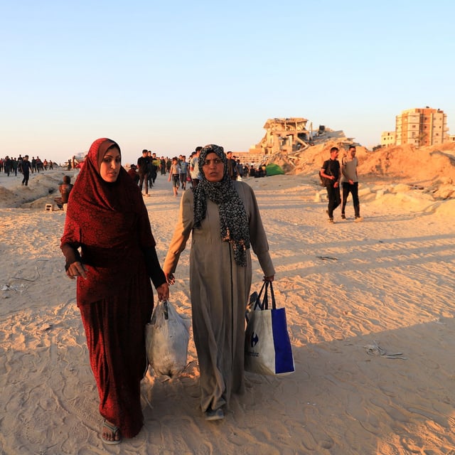 A Palestinian woman, Hind Al-Nawajha, and her sister, Mazouza, walk in search of the United Nations aid trucks entering northern Gaza, in Beit Lahia, in the northern Gaza Strip, June 18, 2025. REUTERS/Ebrahim Hajjaj