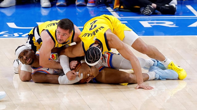 Oklahoma City Thunder guard Shai Gilgeous-Alexander (2) grabs a loose ball as Indiana Pacers guard T.J. McConnell (9) and guard Andrew Nembhard (2) battle for control during the third quarter in game five of the 2025 NBA Finals at Paycom Center. 