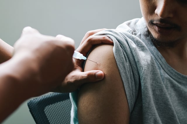 A man receives a vaccination.