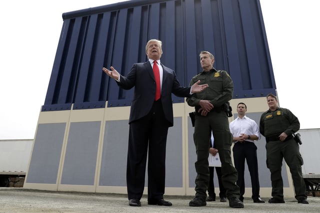 Then-President Donald Trump during a tour as he reviews border wall prototypes, with Rodney Scott, the then-Border Patrol's San Diego sector chief, in San Diego, on March 13, 2018.