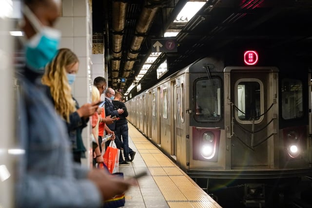 People stand on a platform of the 42nd Street Grand Central Subway Station as the 5 train arrives Tuesday, May 18, 2021, in New York.