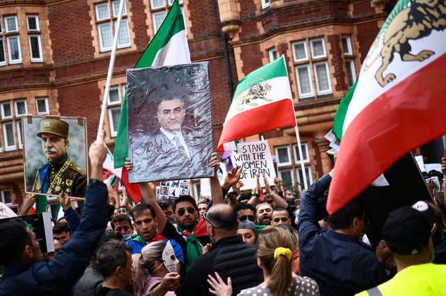 A man holds an image of Reza Pahlavi, as people protest against the Iranian regime, following the death of Mahsa Amini, outside Iran's consulate, in London, Britain, October 9, 2022. REUTERS/Henry Nicholls/File Photo