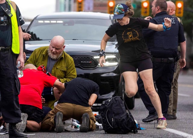 People rush to give medical assistance to a man shot during a “No Kings” protest in Salt Lake City on Saturday, June 14, 2025.