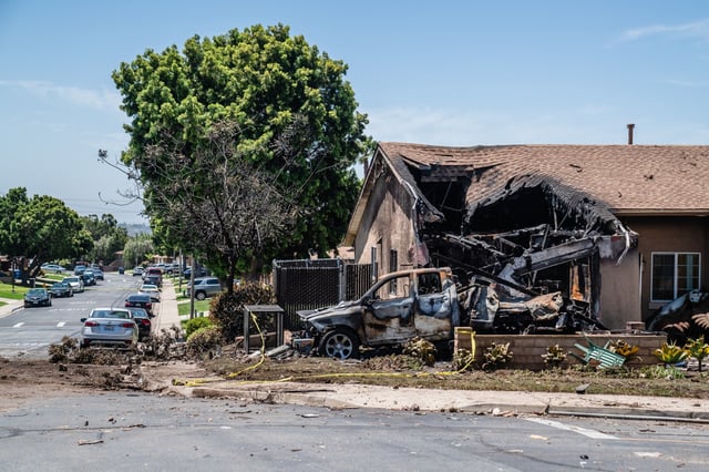 SAN DIEGO, CALIFORNIA - MAY 22: A house is damaged after a small plane crashed into a neighborhood, setting homes and vehicles on fire on May 22, 2025 in San Diego, California. At least two people have died after a Cessna 550 aircraft crashed into a residential street in Murphy Canyon, causing evacuations after buildings were damaged.   (Photo by Ariana Drehsler/Getty Images)