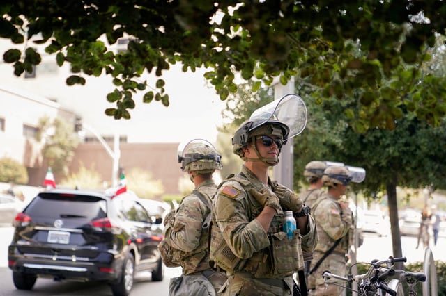 U.S. Marines stand watch as people protest against U.S. President Donald Trump's policies and federal immigration sweeps during a No Kings Day demonstration in Los Angeles, California, U.S., June 14, 2025.  REUTERS/David Ryder/File Photo