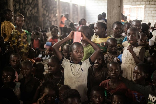 Des enfants attendent une distribution de produits alimentaires dans le camp de personnes déplacées de Buhimba, le 22 décembre 2024 en RDC