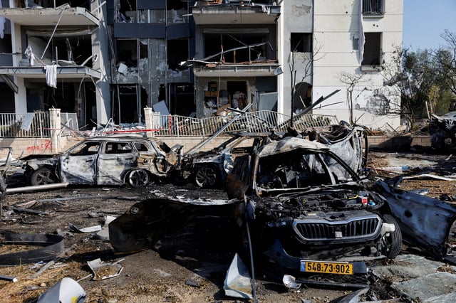 A view of burnt cars and a damaged residential building at an impact site following Iran's missile strike on Israel, in Be'er Sheva, Israel, June 20, 2025. REUTERS/Amir Cohen