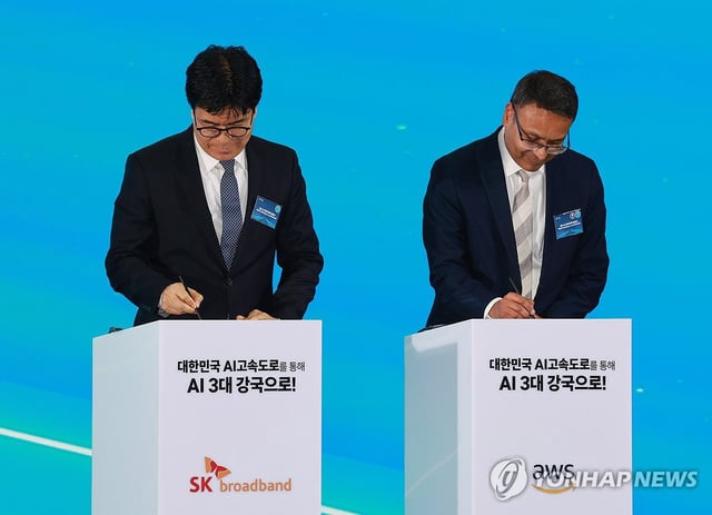 Park Jin-hyo (L), CEO of SK Broadband, and Prasad Kalyanaraman, vice president of AWS Infrastructure Services at Amazon Web Services, sign an agreement on the construction of the artificial intelligence data center during a ceremony held at the Ulsan Exhibition & Convention Center in the southeastern city of Ulsan on June 20, 2025. (Pool photo) (Yonhap) 