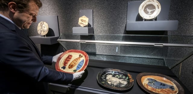 Un plat en terre cuite "Trois poissons" (vers 1952) du peintre espagnol Pablo Picasso, exposé avec d'autres oeuvres en céramique à la maison de vente Piguet à Genève, le 5 juin 2025 avant une vente aux enchères