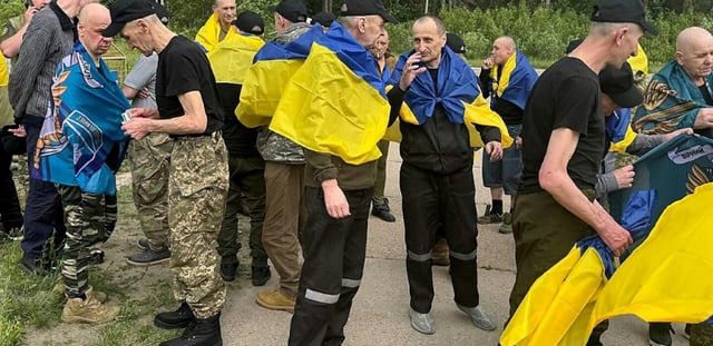 Photo non datée publiée sur la chaîne Telegram officielle du président ukrainien Volodymyr Zelensky, le 19 juin 2025, de prisonniers de guerre ukrainiens (PG) enveloppés dans le drapeau national après un échange de prisonniers dans un lieu non divulgué en Ukraine