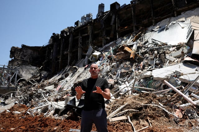 Professor Roee Ozeri speaks to the media surrounded by rubble at the campus of the Weizmann Institute caused by an Iranian missile strike on Sunday, in Rehovot, Israel. REUTERS/Violeta Santos Moura