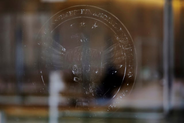 The name and logo for the Consumer Financial Protection Bureau (CPFB) is seen scraped off the door of its building in Washington, D.C., U.S., February 20, 2025. REUTERS/Brian Snyder/File Photo