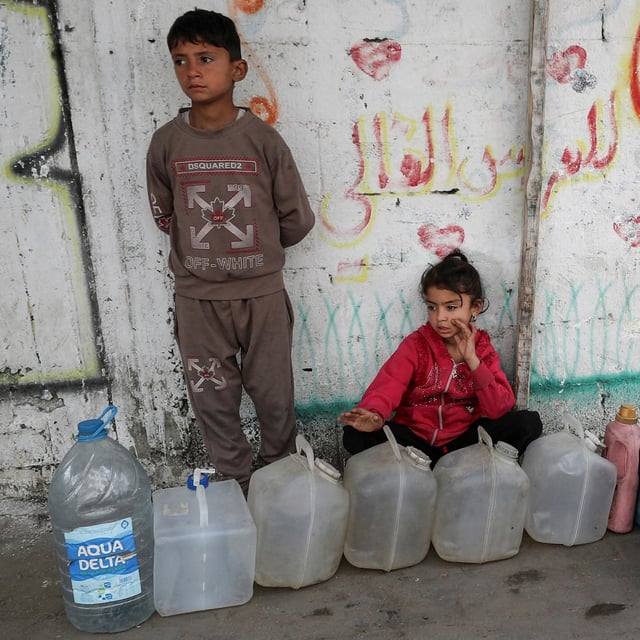 Palestinian children near containers used for water in Gaza City on April 6. Unicef says only 40 per cent of drinking water facilities remain functional in Gaza.