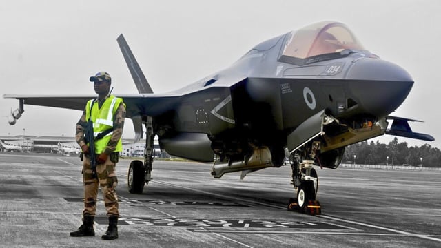 A CISF personnel stand guard near the British F-35 fighter jet that made an emergency landing after running low on fuel at the Thiruvananthapuram International Airport on Saturday night.
