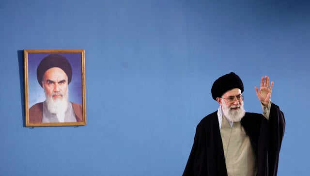 In this 2006 photo, Iran's supreme leader Ayatollah Ali Khamenei waves next to a portrait of Iran's late founder of Islamic republic Ayatollah Khomeini during a meeting in Tehran.