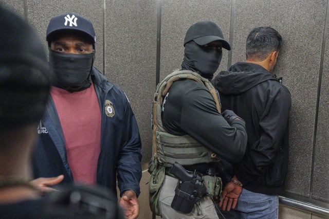 Immigration and Customs Enforcement agents escort a detained immigrant into an elevator after he exited an immigration courtroom, Tuesday, June 17, 2025, in New York.