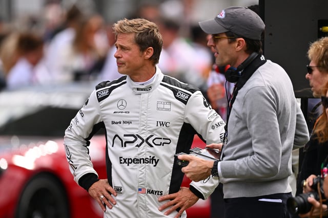 Brad Pitt, star of the upcoming Formula One based movie, Apex, and Joseph Kosinski, director of the upcoming Formula One based movie, Apex, talk on the grid during the F1 Grand Prix of Great Britain at Silverstone Circuit on July 09, 2023 in Northampton, England.