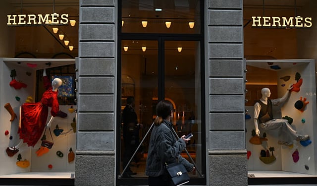 A woman walks past a Hermes boutique in Via Monte Napoleone, a famous upscale shopping street in Milan.