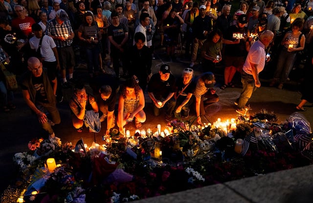 People place candles at a memorial on the steps outside the Minnesota State Capitol building during a candlelight vigil on June 18, 2025, in St. Paul, Minn.
