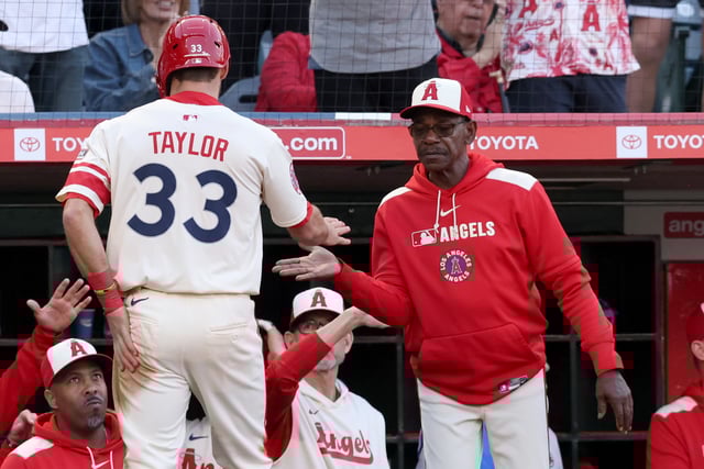 Jun 6, 2025; Anaheim, California, USA; Los Angeles Angels outfielder Chris Taylor (33) celebrates with manager Ron Washington (37) after scoring during the third inning against the Seattle Mariners at Angel Stadium. Mandatory Credit: Jason Parkhurst-Imagn Images/File Photo
