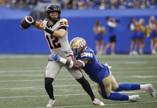 BC Lions quarterback Nathan Rourke gets wrapped up by Winnipeg Blue Bombers’ Willie Jefferson during first game in Winnipeg June 12, 2025.