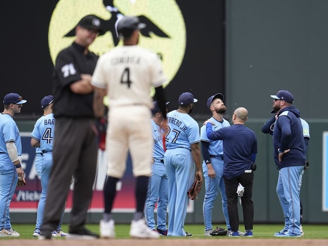 Toronto Blue Jays right fielder Nathan Lukes (38), middle right, is looked at by a trainer after a collision with teammate second baseman Ernie Clement (22) during the sixth inning of a baseball game against the Minnesota Twins, Sunday, June 8, 2025, in Minneapolis.