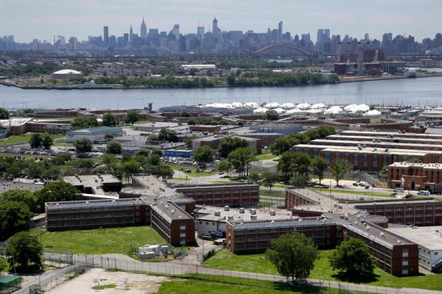 FILE - The Rikers Island jail complex stands with the Manhattan skyline in the background on June 20, 2014, in New York. A new report finds widespread unsanitary conditions at Rikers Island. It comes as a federal judge is weighing a receivership for the notorious New York City jail complex. (AP Photo/Seth Wenig, File)