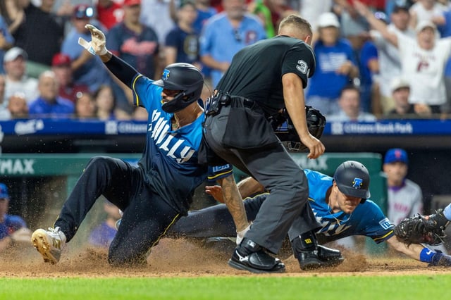 Philadelphia Phillies Nick Castellanos, left, and J.T. Realmuto, right, score on an RBI single by Bryson Stott in the seventh inning of a baseball game against the New York Mets, Friday, June 20, 2025, in Philadelphia. (AP Photo/Laurence Kesterson)