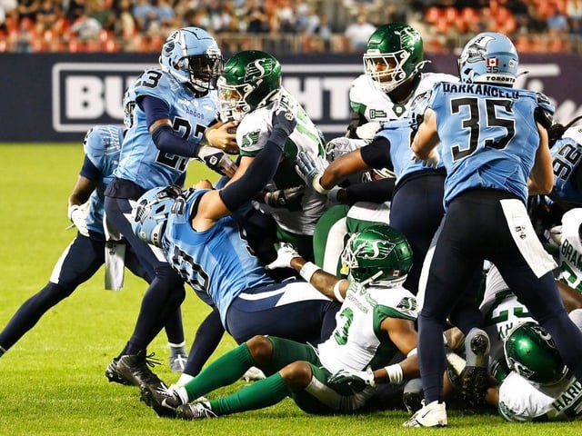 Saskatchewan Roughriders quarterback Tommy Stevens, centre, is stopped by the Toronto Argonauts defence, short of scoring a touchdown during second half CFL football action in Toronto Friday, June 20, 2025.