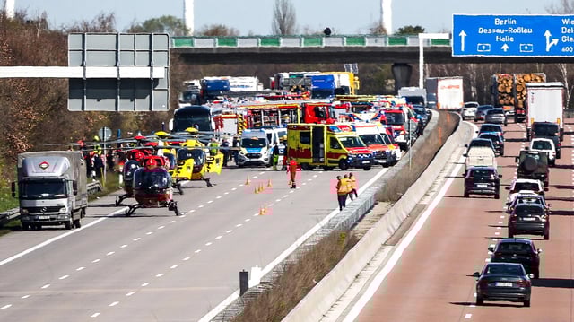 Zahlreiche Rettungshubschrauber- und Wagen auf der Fahrbahn einer gesperrten Autobahn.